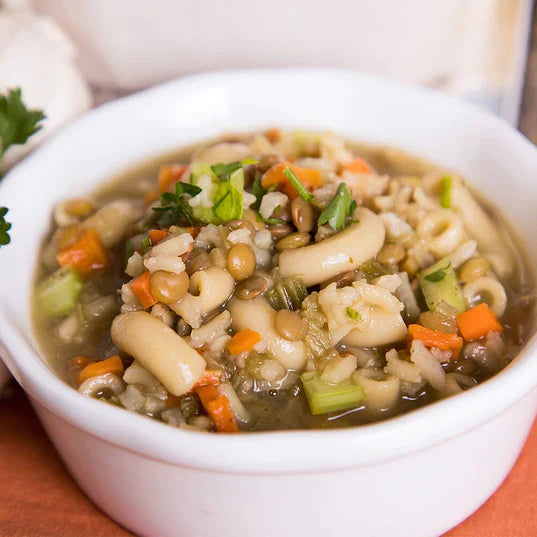 traveler's stew in white bowl on orange cloth with green garnish