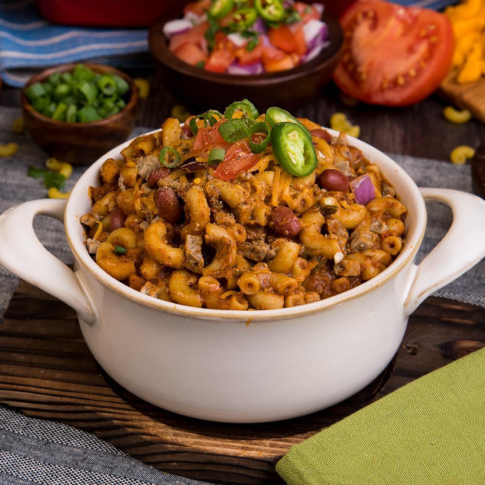 chili mac in white dish white jalapeno chive and tomato topping