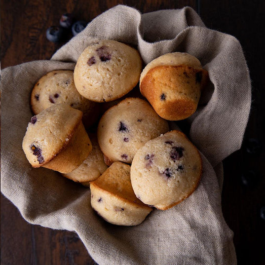 seven blueberry breakfast muffins wrapped in grey cloth