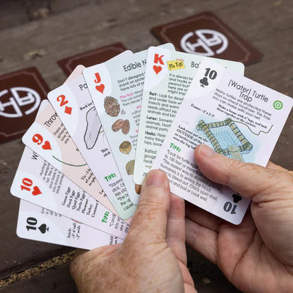 traps snares and primitive weapons playing cards in two hands being played