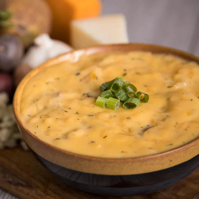 potato cheddar soup with chives on top in yellow and brown bowl b